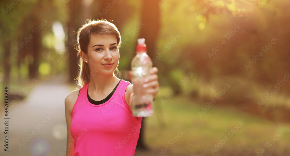 Beautiful fitness athlete runner woman drinking water in the park. Water bottle Beautiful fitness athlete runner woman drinking water in the park. Water bottle