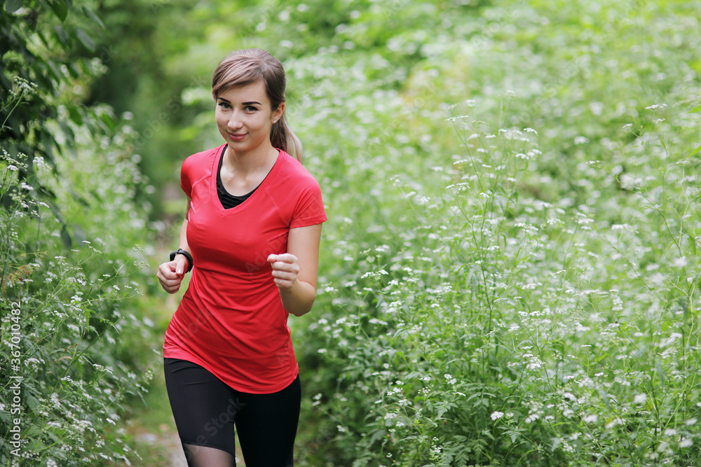 Young fitness woman running in the morning forest trail. Healthy fit living. Young fitness woman running in the morning forest trail. Healthy fit living.