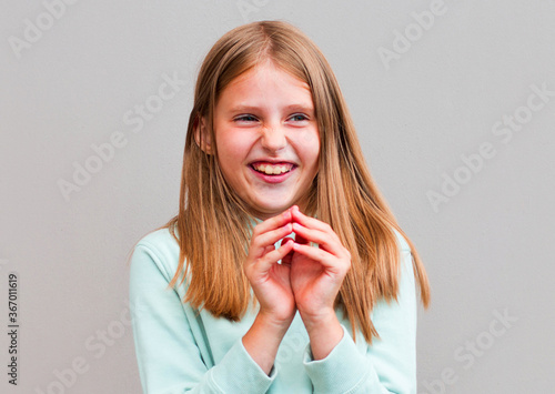 Фотография Portrait of sly woman looking with cunning eyes holding her hands together trying to ask something in sly manner