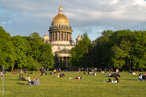  Lawn on Senate Square with people resting in front of St. Isaac's Cathedral. Saint Petersburg, Russia