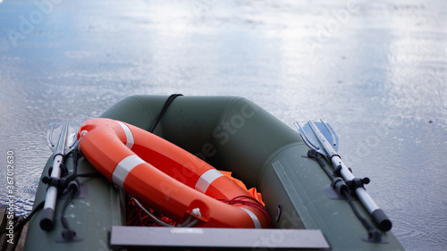 Photography inflatable lifeboat with a lifebuoy on Board floats in the lake during the rain