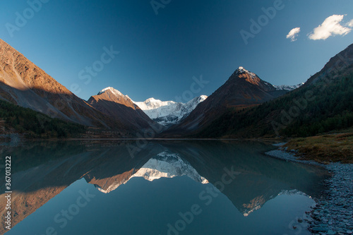 Fototapeta Naklejka Na Ścianę i Meble -  lake in the mountains with tops in the snow horizontally close-up 