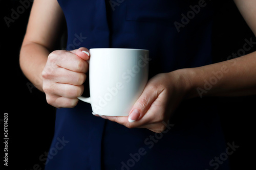 coffee mug in female hands. a woman in business office style clothes cooks a cup. mug for your design or promotional text message promotional content.