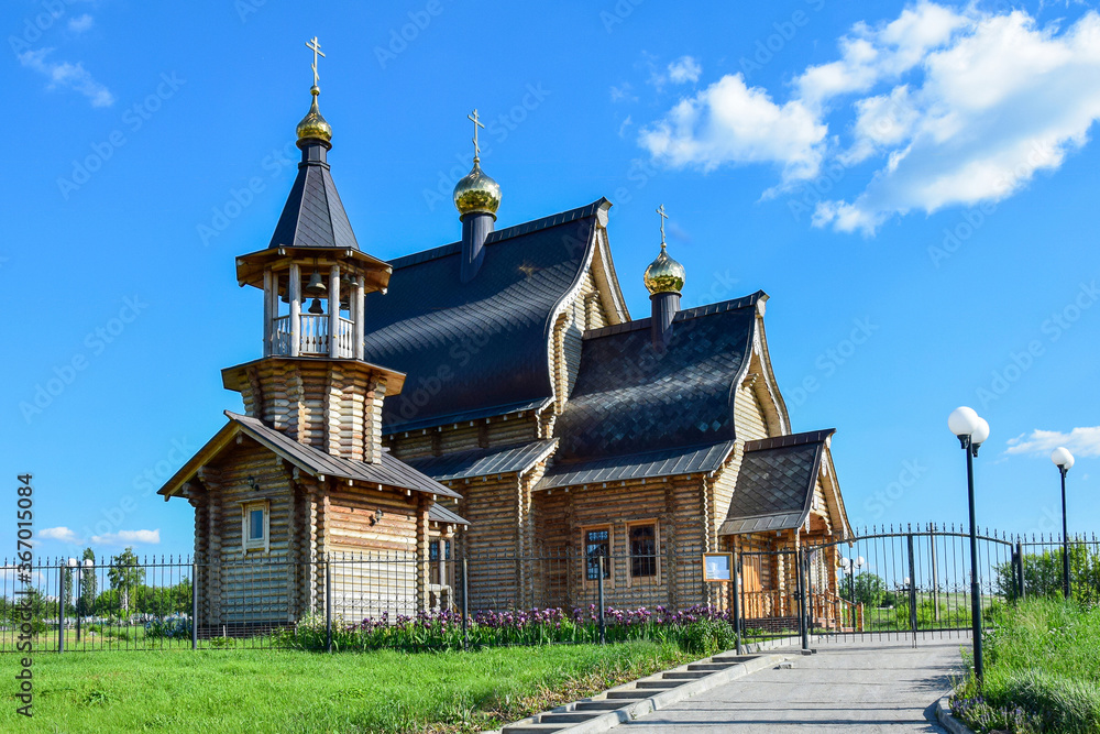 Photo of a wooden Orthodox Church with Golden domes Photo of a wooden Orthodox Church with Golden domes