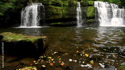 4k footage of a beautiful waterfall surrounded by lush green foliage in a forest (Sgwd y Pannwr, Brecon Beacons, Wales) photo
