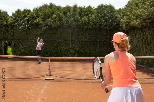 Female tennis player training with trainer on the clay court, sport concept © Khaligo