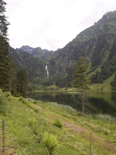 View onto waterfall over a lake amidst forest mountains  © V. D. Grade
