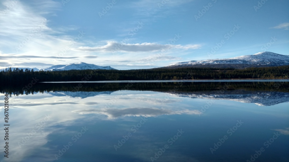 reflection of clouds and mountains in lake