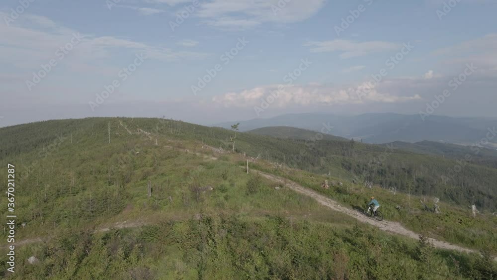 Aerial shot of mountainbike woman cycling in summer mountains landscape. Woman cycling MTB trail outdoor adventure.. Aerial shot of mountainbike woman cycling in summer mountains landscape. Woman cycling MTB trail outdoor adventure..