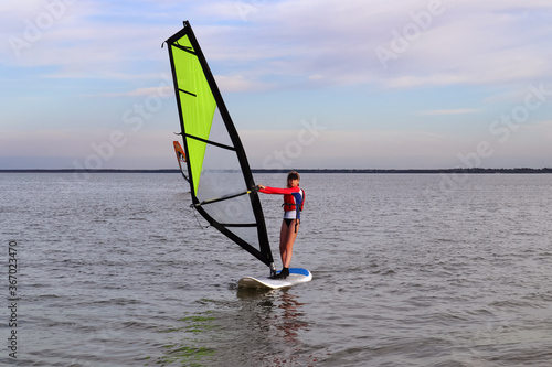 Teen girl windsurfer rides on the sea water sports  © Sasha Al