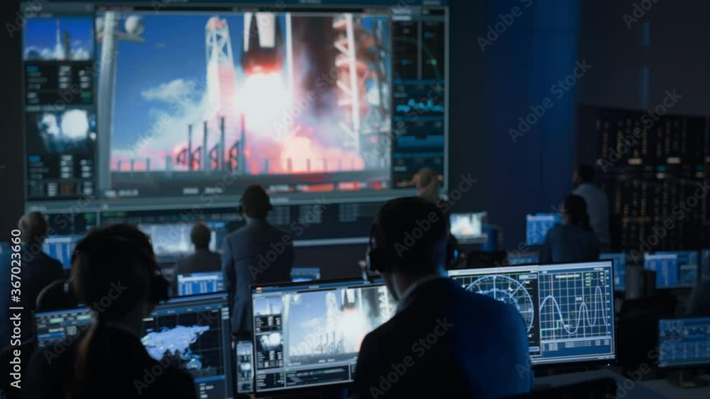 Group of People in Mission Control Center Witness Successful Space Rocket Launch. Flight Control Employees Sit in Front Computer Displays and Monitor the Crewed Mission. Team Stand Up and Clap Hands. Group of People in Mission Control Center Witness Successful Space Rocket Launch. Flight Control Employees Sit in Front Computer Displays and Monitor the Crewed Mission. Team Stand Up and Clap Hands.