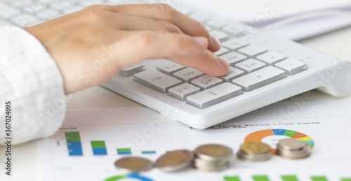 Woman with beautiful hands working on the calculator and keyboar photo