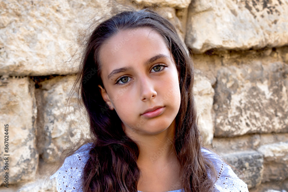 Portrait beautiful tanned caucasian girl against ancient stone wall. Attractive young tourist woman visiting city street old textured stone walls summer holiday, outdoors. Travel and lifestyle Portrait beautiful tanned caucasian girl against ancient stone wall. Attractive young tourist woman visiting city street old textured stone walls summer holiday, outdoors. Travel and lifestyle