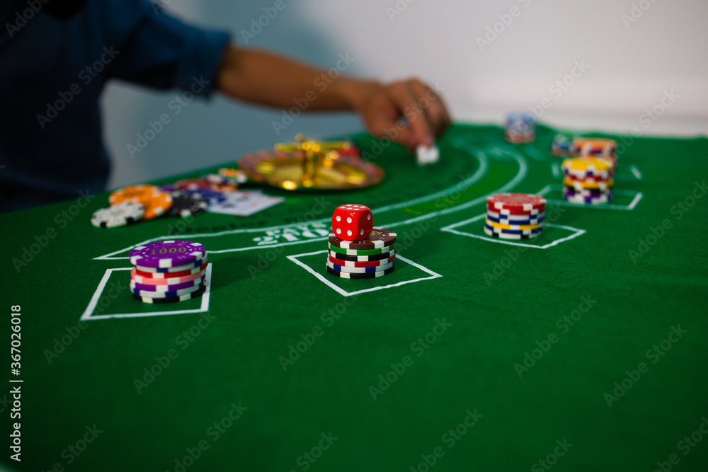 man hand hold Casino equipment placed on the green floor for risky gambling for the people who want to get rich. man hand hold Casino equipment placed on the green floor for risky gambling for the people who want to get rich.