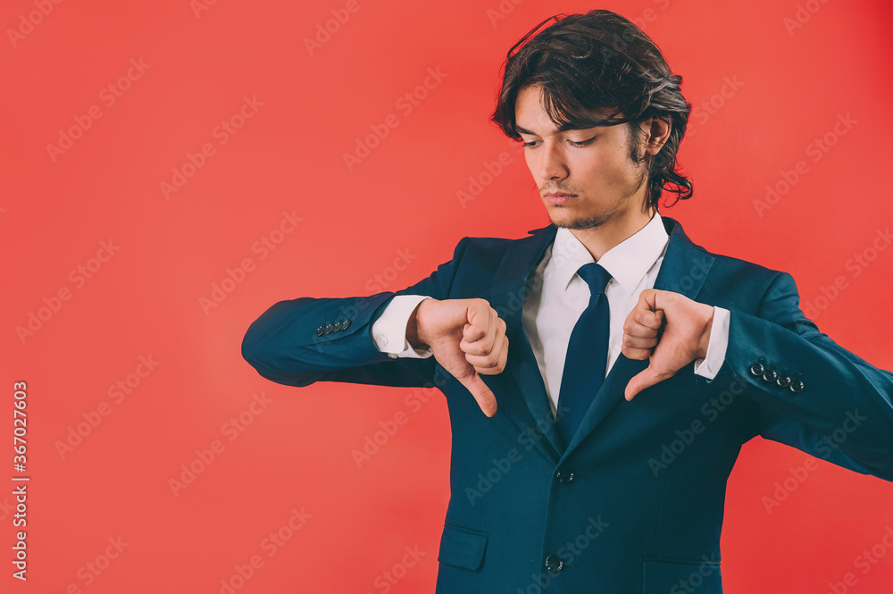 Businessman shows thumbs down over red background. Businessman shows thumbs down over red background.