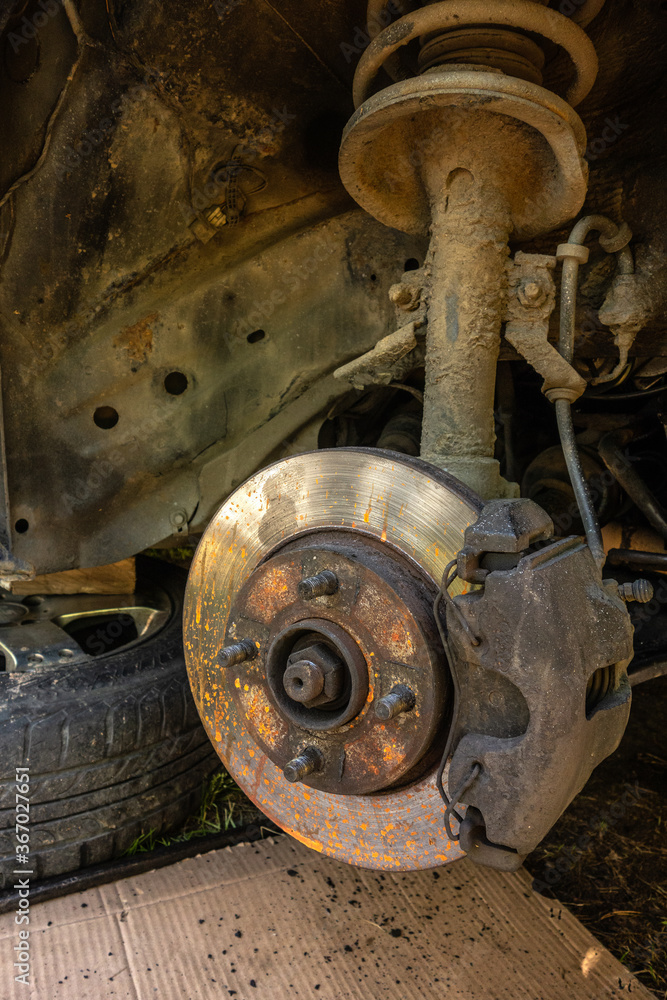 Old, rusty disc brakes and pads on the car in repair Old, rusty disc brakes and pads on the car in repair