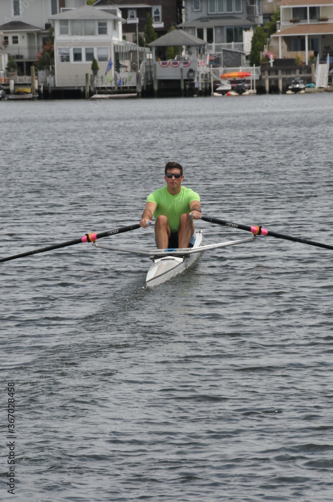 Rower and his single scull (shell) going out for some exercise on the water. Rower and his single scull (shell) going out for some exercise on the water.