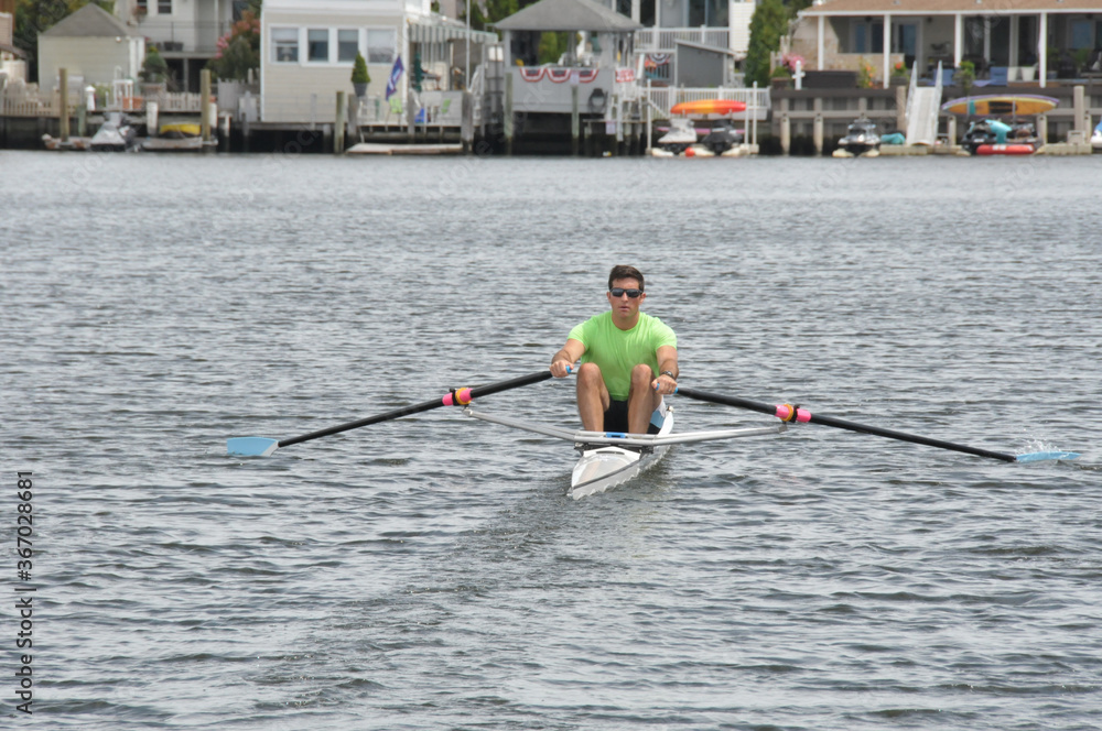 Rower and his single scull (shell) going out for some exercise on the water. Rower and his single scull (shell) going out for some exercise on the water.