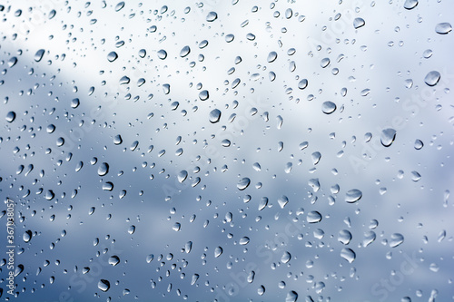 raindrops on the window on a blue sky with clouds