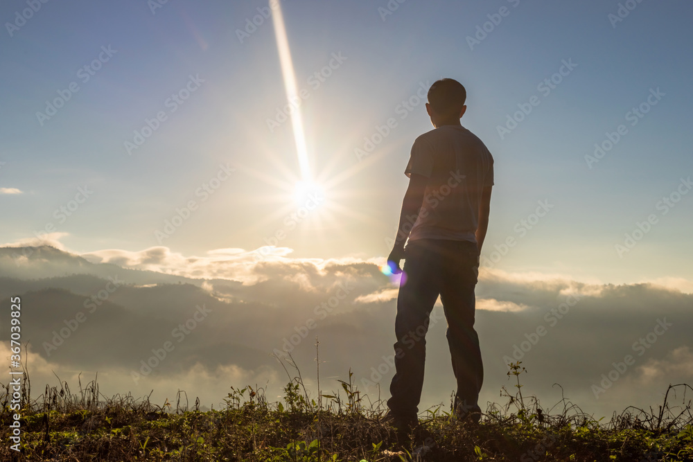 Fototapeta premium Young man looking beautiful view of foggy mountains landscape