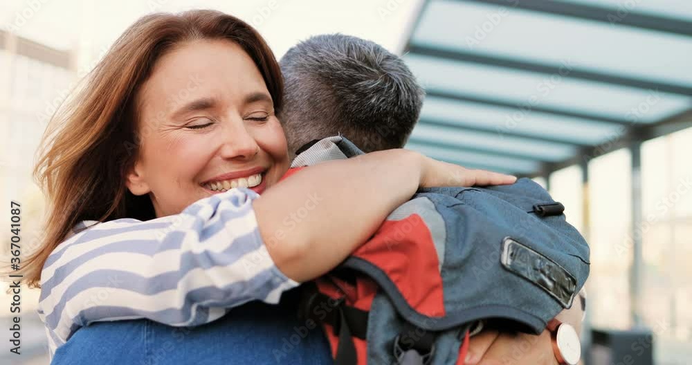 Close up of young Caucasian couple in love meeting and hugging after long separation. Outdoor. Beautiful woman meet and embracing husband or boyfriend coming back from tour. Embraces after travelling. Close up of young Caucasian couple in love meeting and hugging after long separation. Outdoor. Beautiful woman meet and embracing husband or boyfriend coming back from tour. Embraces after travelling.