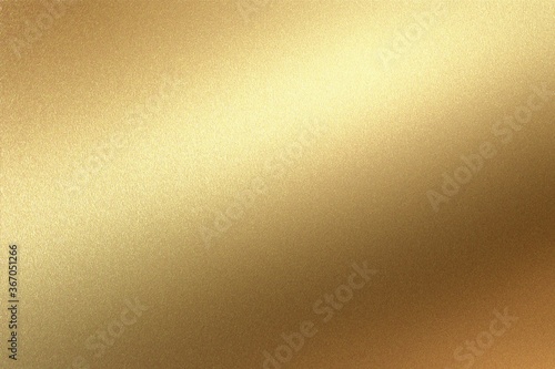 Glowing gold foil metal panel wall with copy space, abstract texture background