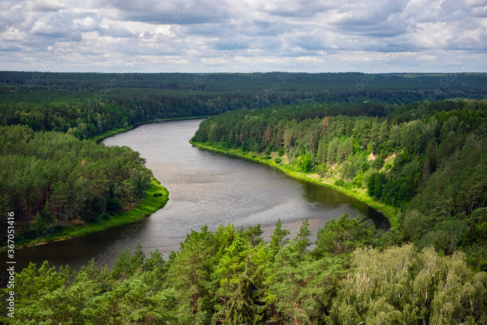 Aerial view of beautiful river Nemunas surrounded by pine forest in Lithuania. Birdseye view of nature scene on a sunny day. Aerial view of beautiful river Nemunas surrounded by pine forest in Lithuania. Birdseye view of nature scene on a sunny day.
