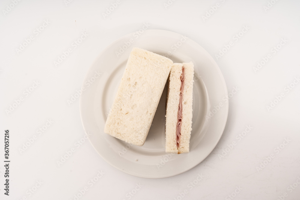 Sandwich made by white bread, ham and mayonnaise on white background.