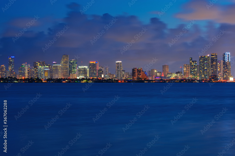Miami night. Skyline city miami lighting lights sea ocean sunset night cityscape buildings downtown, architecture skyscraper dusk panorama.