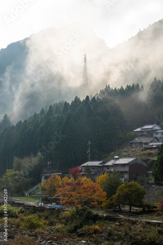 山岳地帯の町並みと鉄塔と朝靄