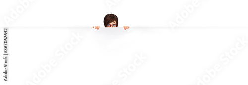 Slika na platnu A young woman shows emotion as she peers over the top of a white on white wall in this illustration