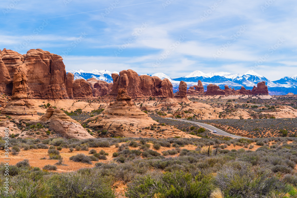 Red sandstone rocks with snow capped peaks in the background, Arches National Park, Utah