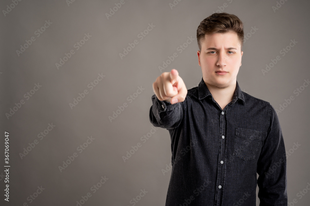 Portrait of serious stylish attractive man dressed in casual black shirt pointing camera Portrait of serious stylish attractive man dressed in casual black shirt pointing camera