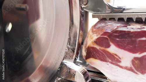 Vintage ham slicing machine during operation.