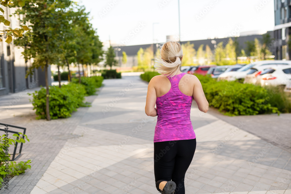 young fitness woman runner running on city road