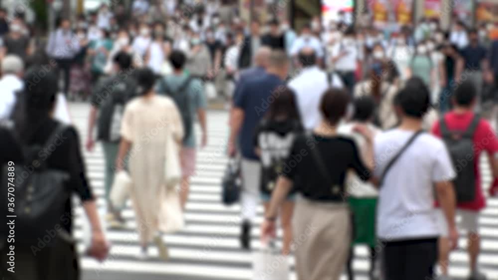 TOKYO, JAPAN - JUL 2020 : Crowd of people at the street near Shinjuku station in rush hour. Commuters wearing surgical mask to protect from Coronavirus (COVID-19) in hot summer. Blurred slow motion. TOKYO, JAPAN - JUL 2020 : Crowd of people at the street near Shinjuku station in rush hour. Commuters wearing surgical mask to protect from Coronavirus (COVID-19) in hot summer. Blurred slow motion.