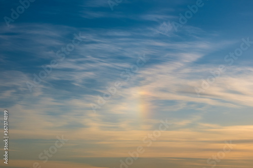 Rainbow and clouds in the sky before sunset. Golden hour. Natural background..
