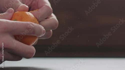 Slow motion man hands peeling tangerine slow motion photo