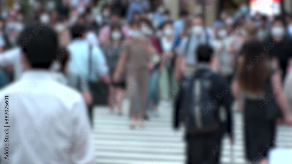 TOKYO, JAPAN - JUL 2020 : Crowd of people at the street near Shinjuku station in rush hour. Commuters wearing surgical mask to protect from Coronavirus (COVID-19) in hot summer. Blurred slow motion. TOKYO, JAPAN - JUL 2020 : Crowd of people at the street near Shinjuku station in rush hour. Commuters wearing surgical mask to protect from Coronavirus (COVID-19) in hot summer. Blurred slow motion.