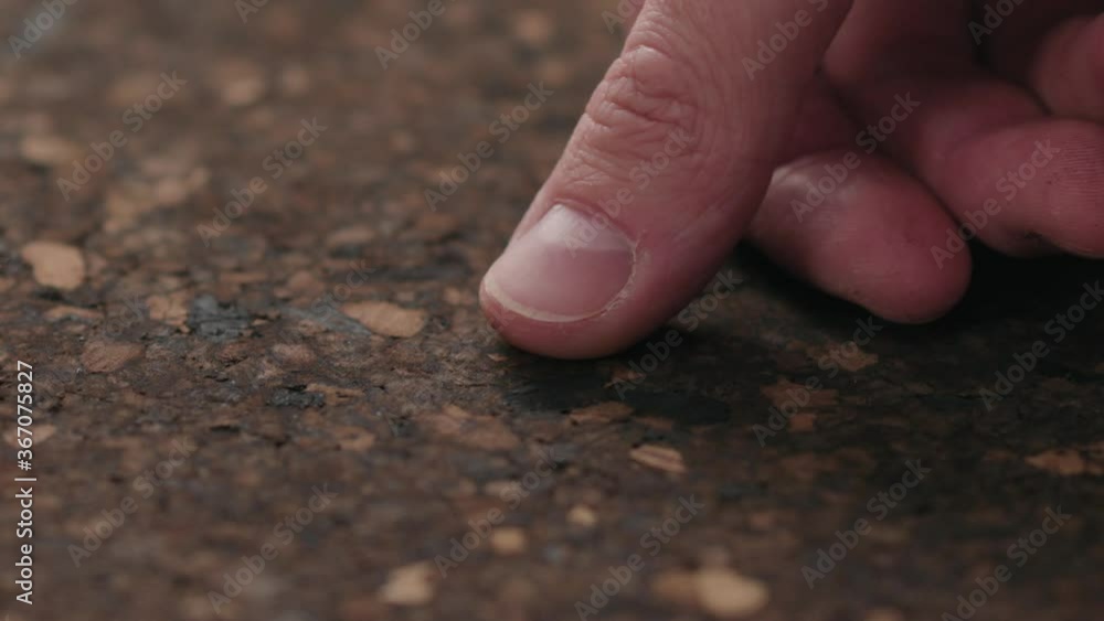 Slow motion man hands touch dark cork surface with oil finish Slow motion man hands touch dark cork surface with oil finish