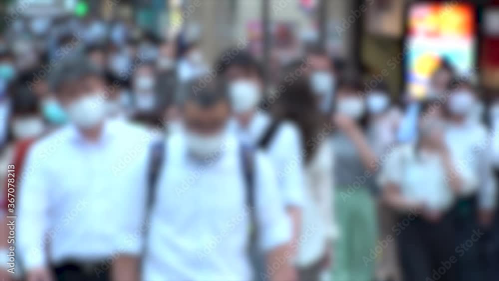TOKYO, JAPAN - JUL 2020 : Crowd of people at the street near Shinjuku station in rush hour. Commuters wearing surgical mask to protect from Coronavirus (COVID-19) in hot summer. Blurred slow motion. TOKYO, JAPAN - JUL 2020 : Crowd of people at the street near Shinjuku station in rush hour. Commuters wearing surgical mask to protect from Coronavirus (COVID-19) in hot summer. Blurred slow motion.