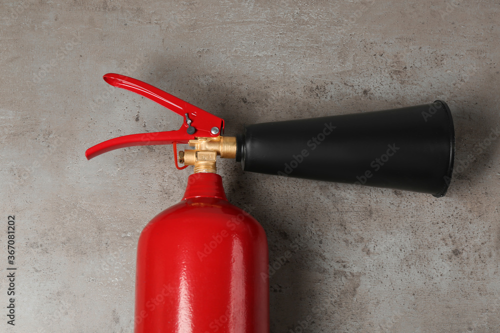 Fire extinguisher on light grey stone background, top view Fire extinguisher on light grey stone background, top view