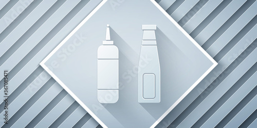 Paper cut Sauce bottle icon isolated on grey background. Ketchup, mustard and mayonnaise bottles with sauce for fast food. Paper art style. Vector Illustration.