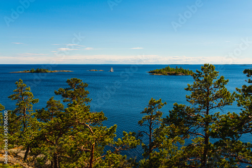 Sunny day on the lake. Bright colorful photo of blue sky, trees and lake in Karelia, Russia.