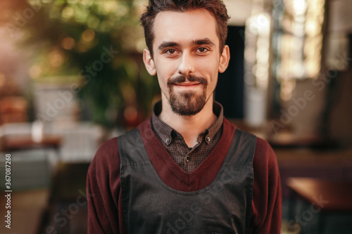 Friendly male barista in cafe