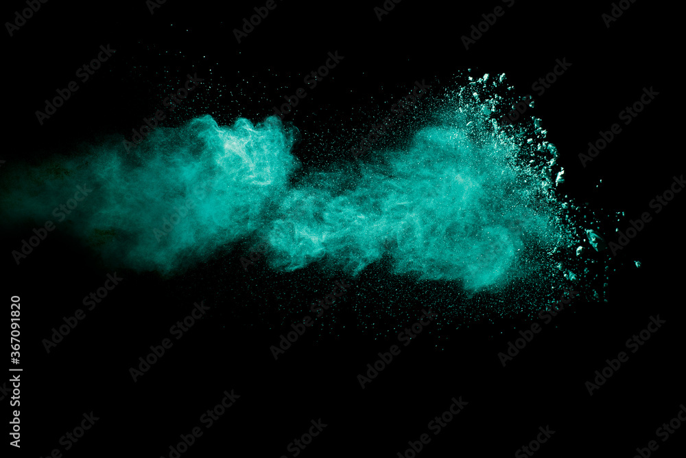 A splatter of green colored powder on black background.