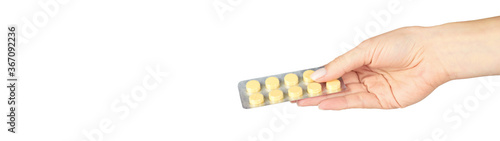 Yellow pills in blister with hand. Isolated on white background. Copy space template, banner.