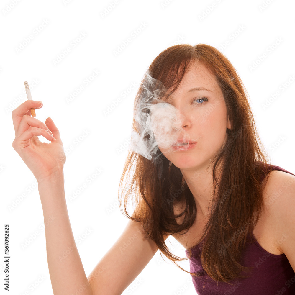 Closeup portrait of a young brunette woman smoking a cigarette, isolated in front of white studio background Closeup portrait of a young brunette woman smoking a cigarette, isolated in front of white studio background
