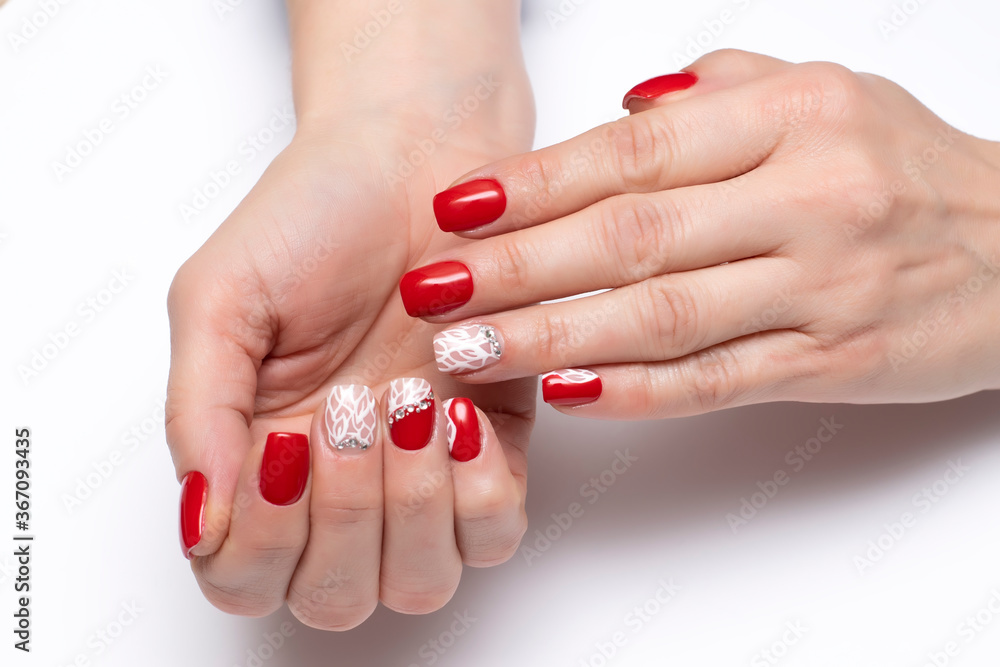 Red manicure with crystals and white spider web on short square nails close-up on a white background. Red manicure with crystals and white spider web on short square nails close-up on a white background.
