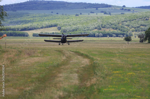 Classic old retro vintage airplane with a propeller takes off from an airfield photo